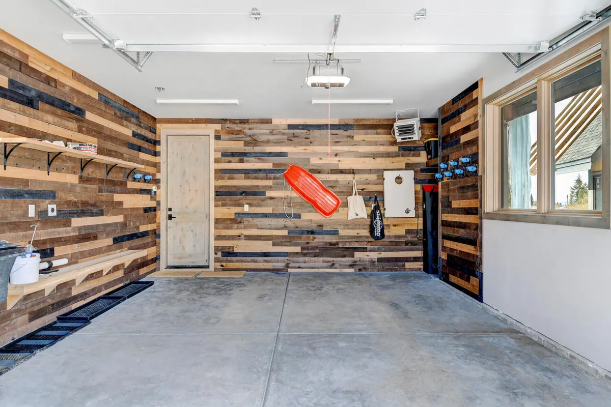 A practical, gear-focused area with a wooden accent wall, red sled, and shelves stocked with tools—clearly designed for storing and preparing sports equipment. The utilitarian style suggests readiness for adventure and easy access to gear.